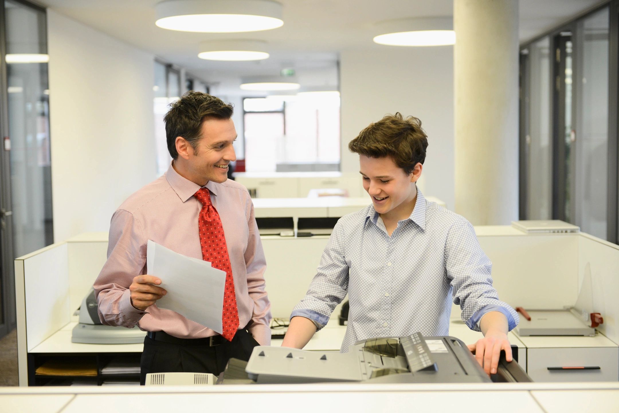 ترجمة معتمدة للهيئة العامة للاستثمار والمناطق الحرة - Two employees copying documents and chatting